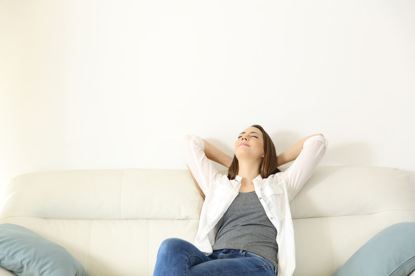 Woman relaxing on a couch with copy space above Woman breathing in air at home