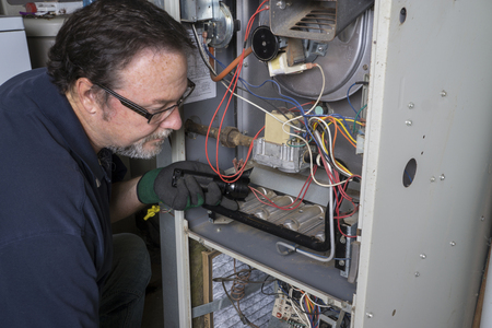 man cleaning furnace for the winter