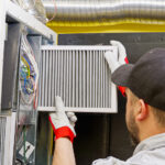 Man cleaning air ducts in building