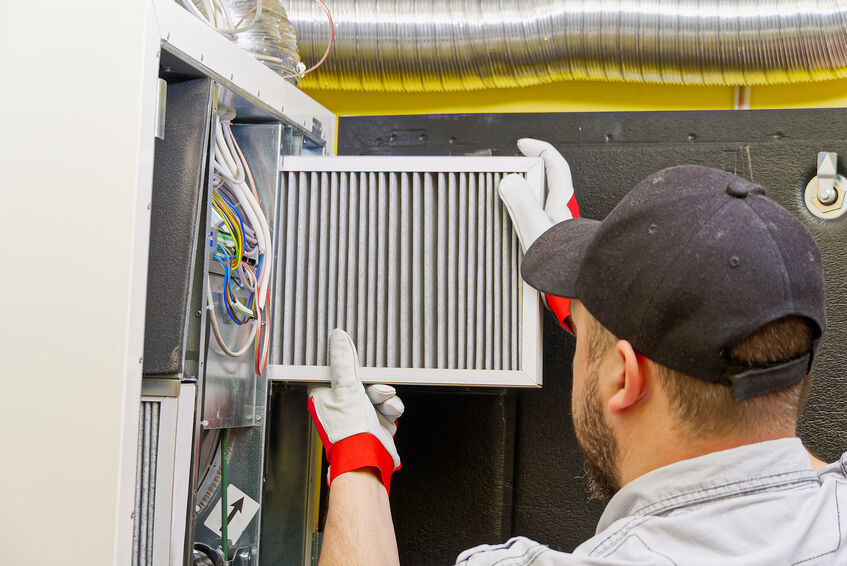 Man cleaning air ducts in building