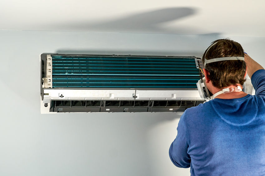 Technician cleaning air duct in a home