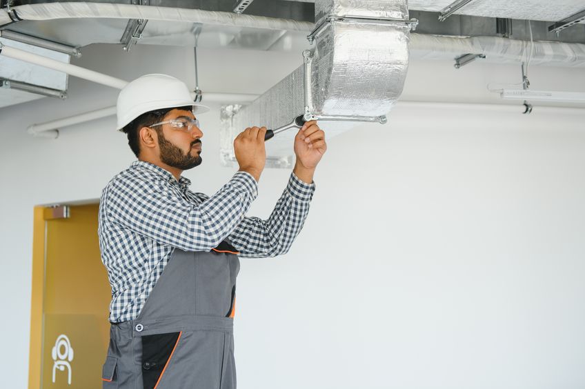 hvac worker install ducted pipe system for ventilation and air conditioning. copy space air duct cleaning in building
